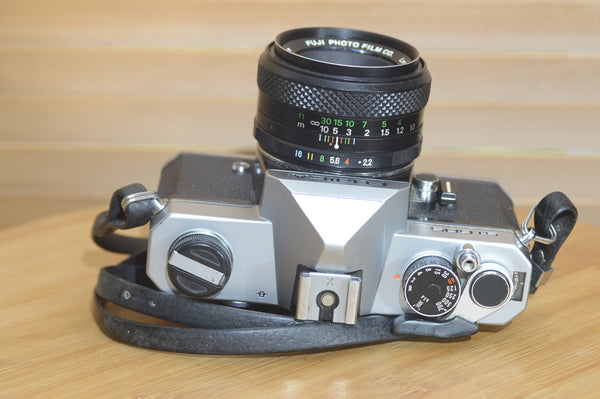 Fujica ST605 35mm SLR camera with 55mm f2.2 lens and case, featuring a vintage, solid build and classic design.