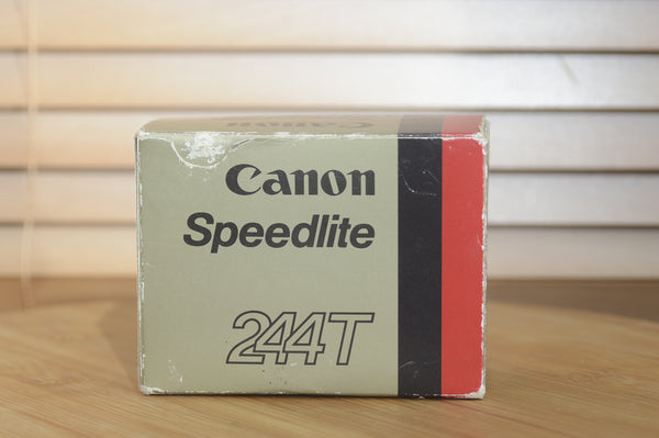 Canon Speedlite 244t flash unit with case, vintage camera accessory, shown in original box with packaging and setup.