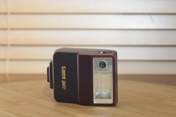 Canon Speedlite 244T flash unit with case and original box, vintage camera accessory for enhanced lighting.