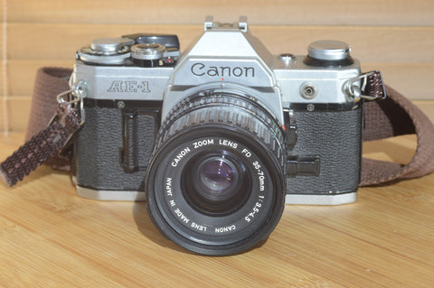 Canon AE1 with Canon FD 35-70mm  lens and strap. Fantastic set up for all levels.