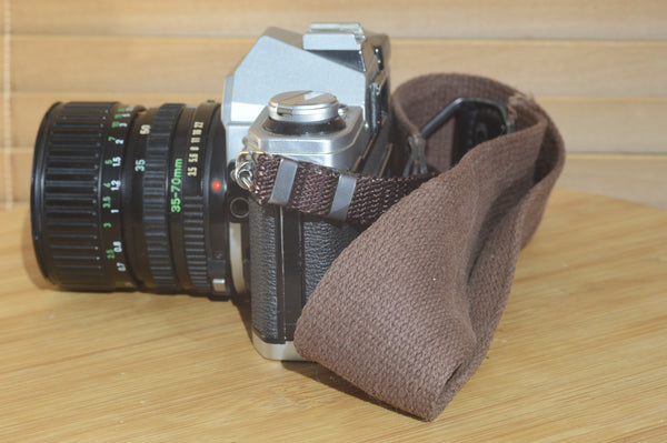 Canon AE1 with Canon FD 35-70mm  lens and strap. Fantastic set up for all levels.
