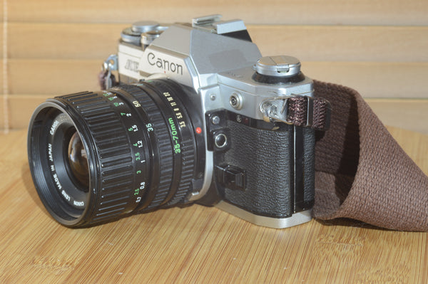 Canon AE1 with Canon FD 35-70mm  lens and strap. Fantastic set up for all levels.