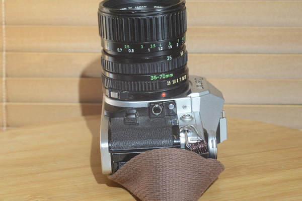 Canon AE1 with Canon FD 35-70mm  lens and strap. Fantastic set up for all levels.