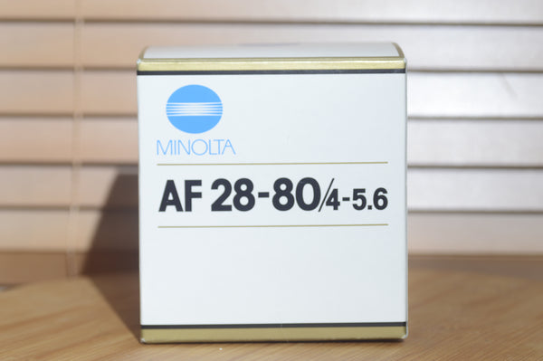 Minolta AF 28-80mm f/3.5-5.6 camera lens with autofocus, shown with box, compatible with Minolta 35mm and digital cameras.