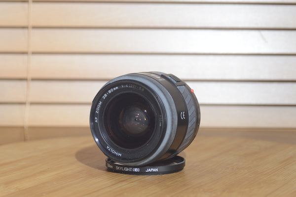 Minolta AF 28-80mm f/3.5-5.6 camera lens with autofocus, shown with box, compatible with Minolta 35mm and digital cameras.