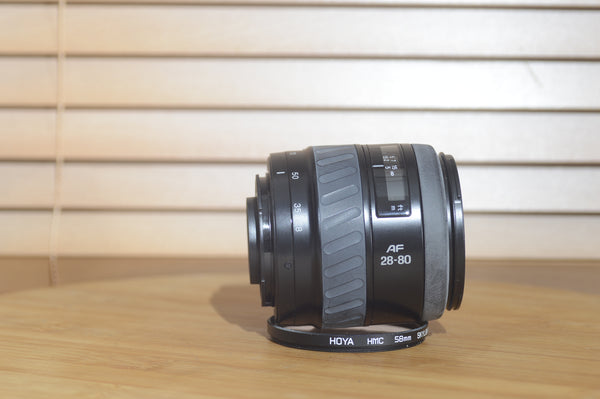 Minolta AF 28-80mm f/3.5-5.6 camera lens with autofocus, shown with box, compatible with Minolta 35mm and digital cameras.