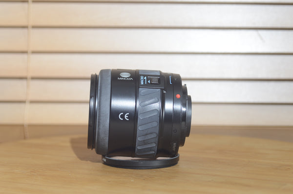 Minolta AF 28-80mm f/3.5-5.6 zoom lens with autofocus, shown with packaging for Minolta 35mm or digital cameras.