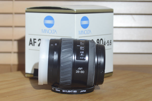 Minolta AF 28-80mm f/3.5-5.6 lens with autofocus, boxed, compatible with Minolta 35mm and digital cameras, shown in the image