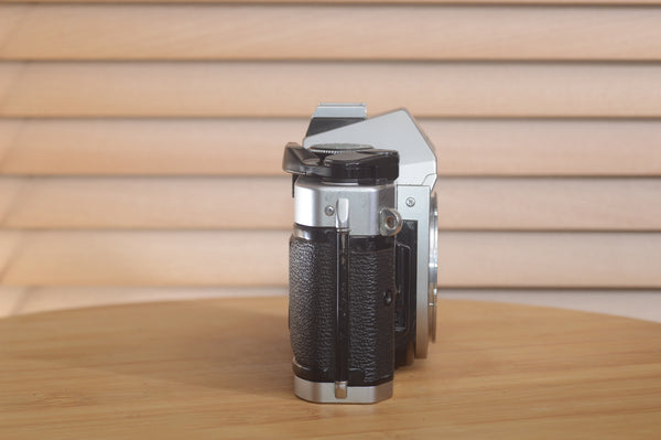 Canon AE1 P 35mm SLR camera body by Rewind Cameras, shown with film advance lever and viewfinder, ready for photography.
