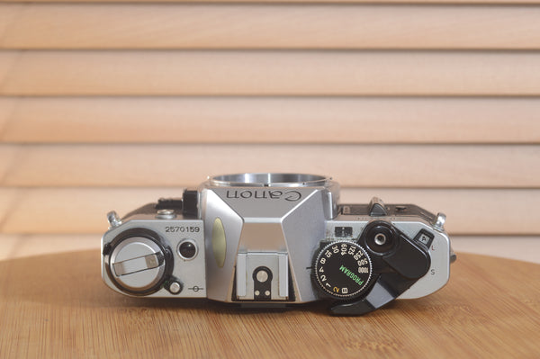 Canon AE1 P 35mm SLR camera body by Rewind Cameras, shown with dials, viewfinder, and textured grip in a close-up shot.