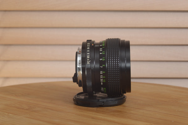 Vivitar Zoom PK Pentax 28-50mm f3.5-4.5 camera lens with front element and aperture ring visible on a white background