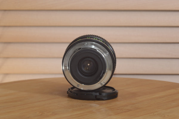 Vivitar Zoom PK (Pentax) 28-50mm f/3.5-4.5 camera lens with focus and zoom rings, mounted on a camera body.