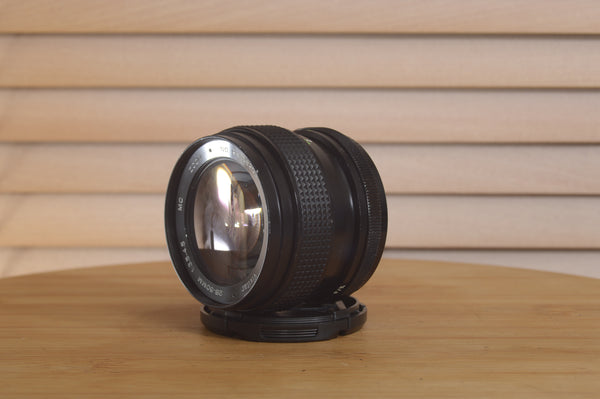 Vivitar Zoom PK (Pentax) 28-50mm f3.5-4.5 camera lens with focus and zoom rings, mounted on a camera body.