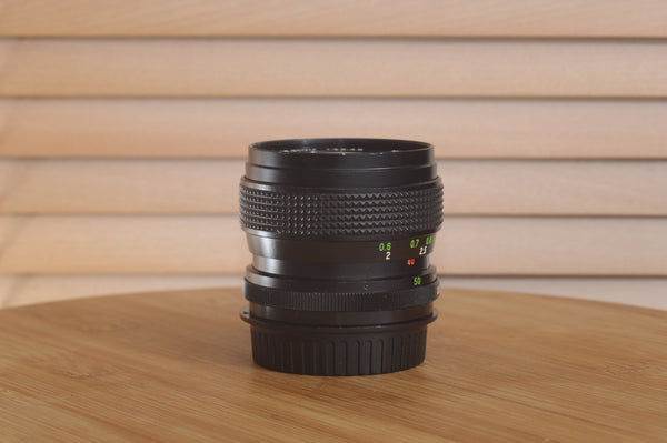 Vivitar Zoom PK (Pentax) 28-50mm f3.5-4.5 camera lens with focus and zoom rings, silver metal body, and lens glass elements.