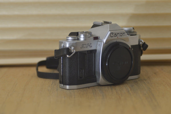 Canon AV1 SLR camera (body only) with very useful strap. These are perfect for beginners or those who want to explore vintage photography. - RewindCameras quality vintage cameras, fully teste